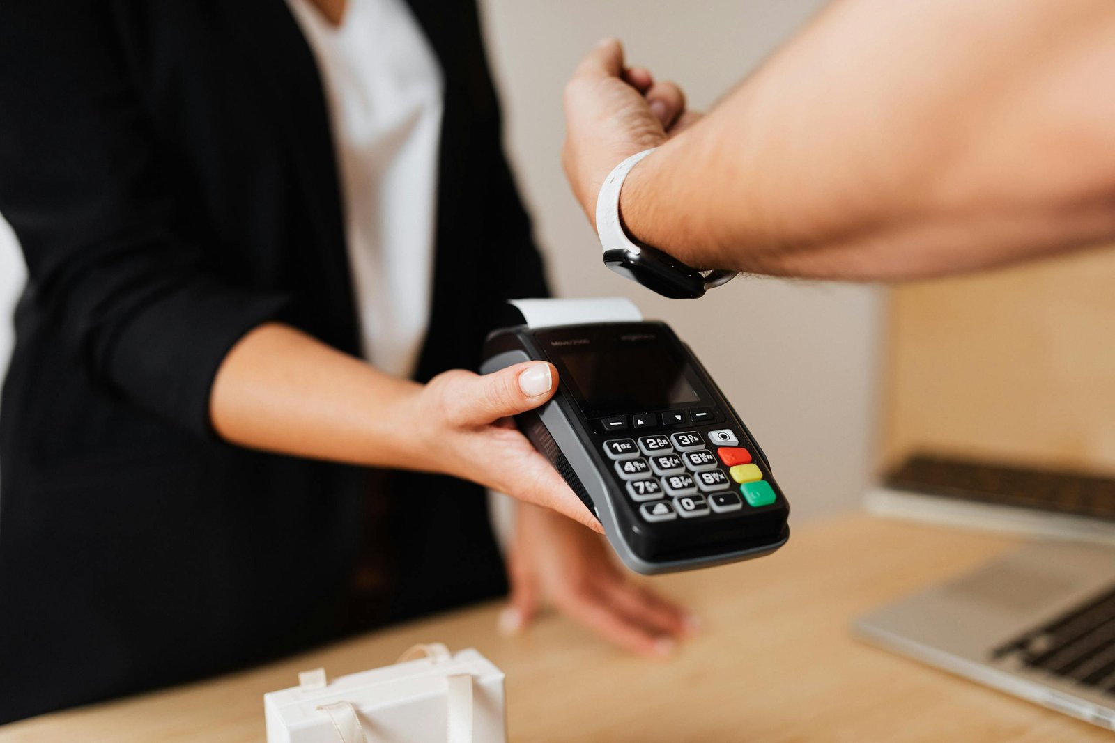Person making a contactless payment using a smartwatch and a payment terminal.